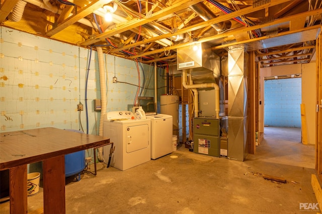 basement featuring independent washer and dryer, heating unit, and water heater