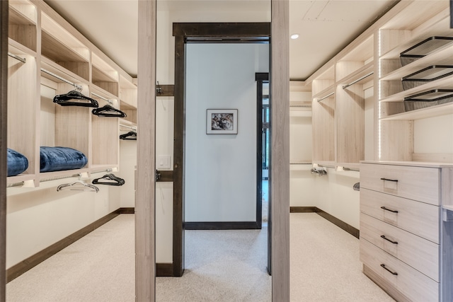 walk in closet featuring light colored carpet