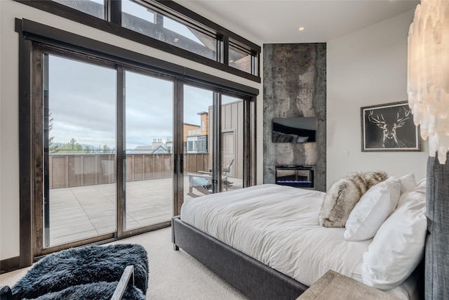 carpeted bedroom with a fireplace and access to outside