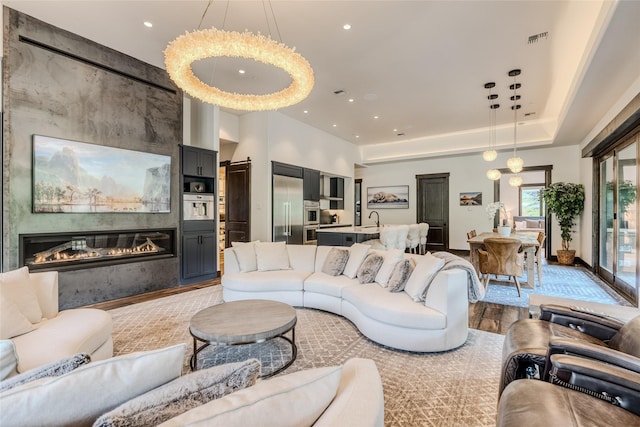 living room with sink, a large fireplace, and light wood-type flooring