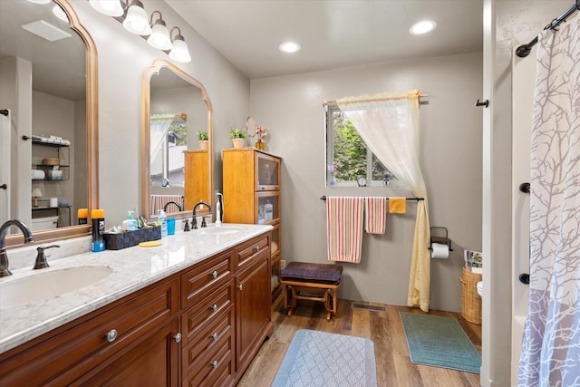 bathroom with hardwood / wood-style floors, vanity, and walk in shower