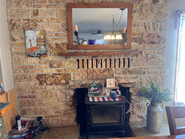 interior details featuring a wood stove and ceiling fan