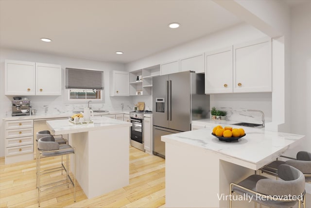 kitchen featuring white cabinets, a kitchen breakfast bar, stainless steel appliances, and a kitchen island