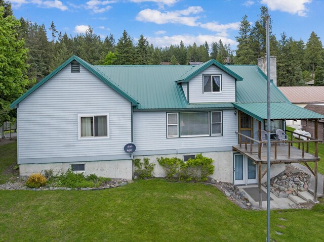 back of house with a lawn and a deck