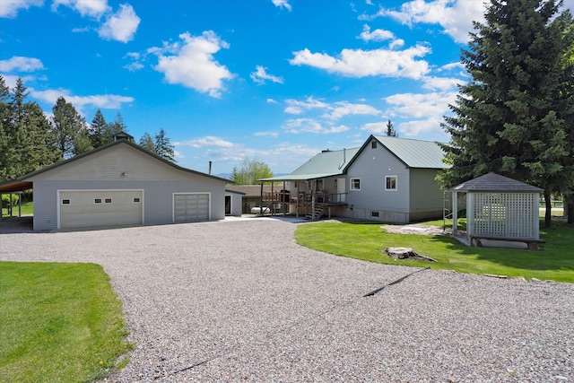 view of side of property with a lawn, a garage, and an outbuilding