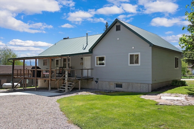 back of property with a wooden deck and a lawn