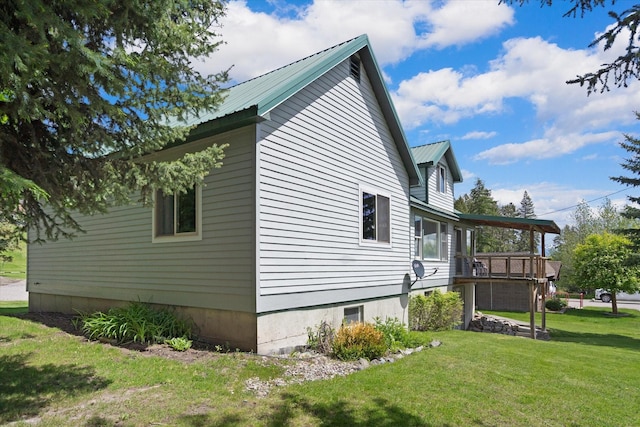 view of home's exterior with a yard and a wooden deck