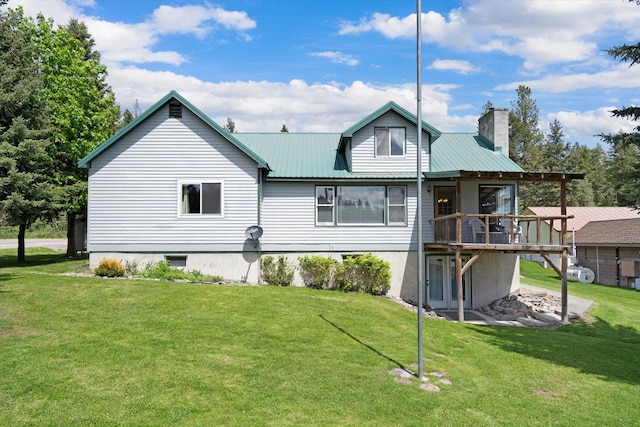 rear view of house featuring a lawn and a wooden deck