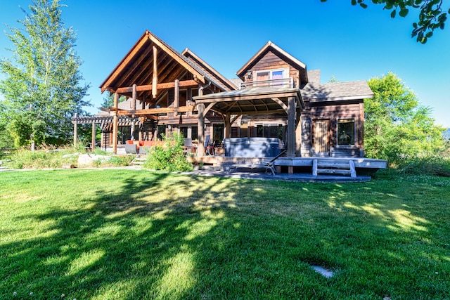 rear view of property with a pergola, a wooden deck, and a lawn