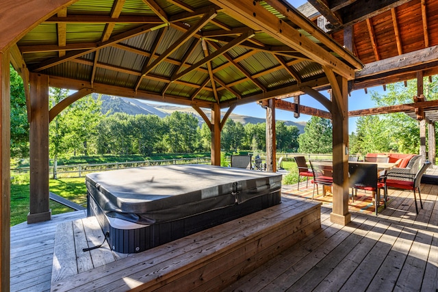 wooden terrace featuring a covered hot tub and a gazebo