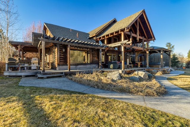 rear view of property featuring a pergola and a yard