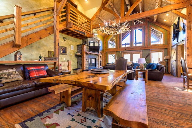 interior space featuring high vaulted ceiling, a chandelier, hardwood / wood-style flooring, and a fireplace