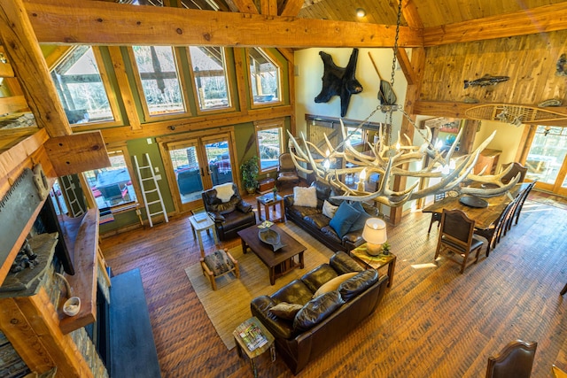 living room with beamed ceiling, high vaulted ceiling, and an inviting chandelier