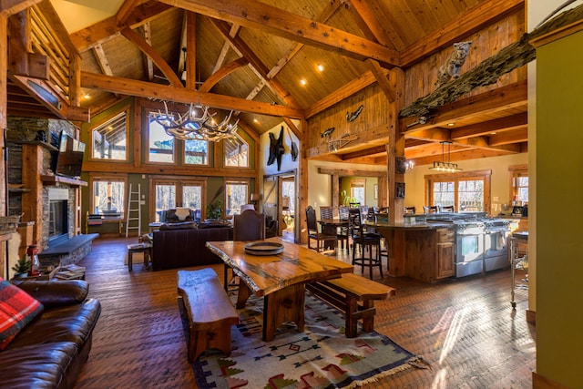 living room featuring high vaulted ceiling, dark hardwood / wood-style flooring, a fireplace, and a chandelier