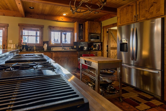 kitchen featuring stainless steel appliances, wooden ceiling, sink, and beam ceiling