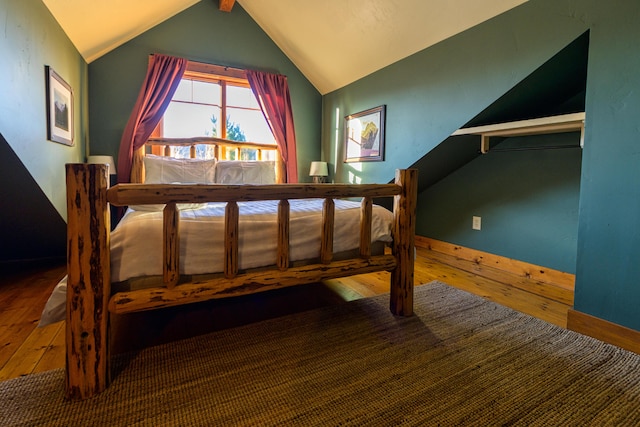 unfurnished bedroom with lofted ceiling and wood-type flooring