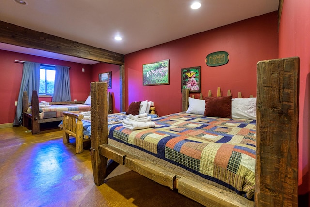 bedroom with beamed ceiling and concrete floors