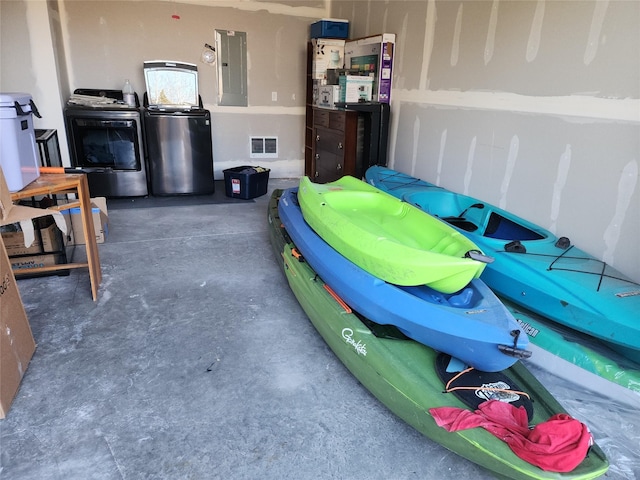 garage featuring electric panel and washing machine and clothes dryer