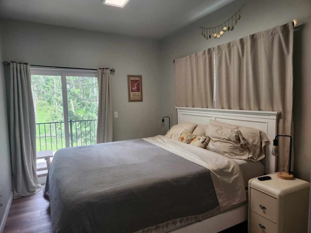 bedroom with access to exterior and dark hardwood / wood-style flooring