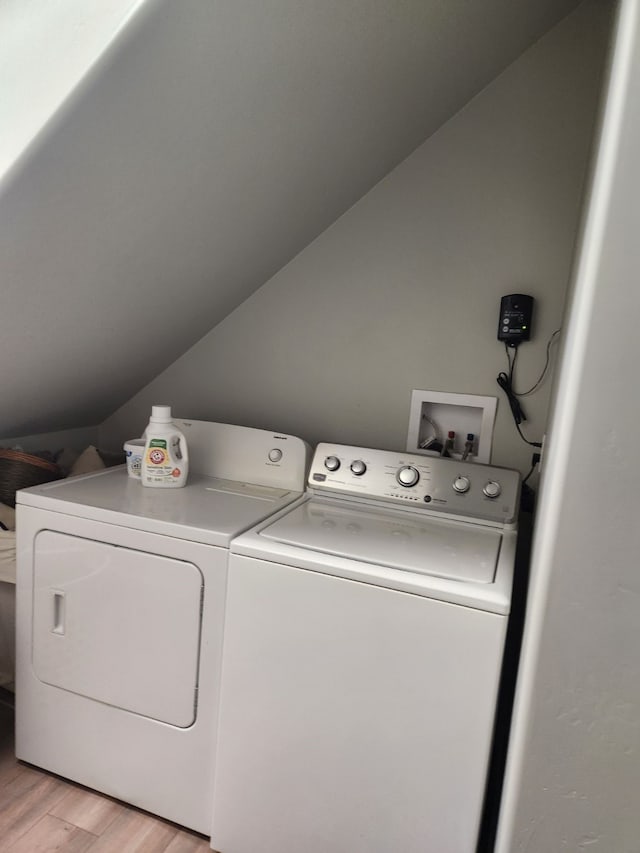 clothes washing area with separate washer and dryer and light hardwood / wood-style flooring