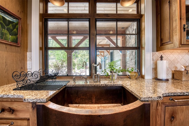 kitchen featuring light stone counters, sink, and decorative backsplash