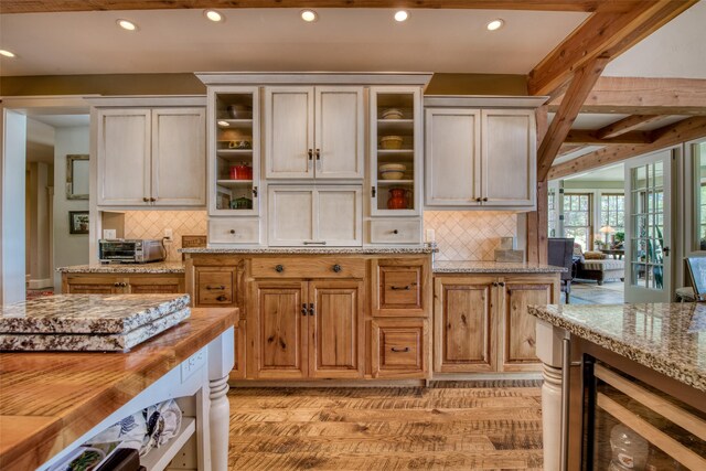 kitchen with light wood-type flooring, wooden counters, beverage cooler, and decorative backsplash