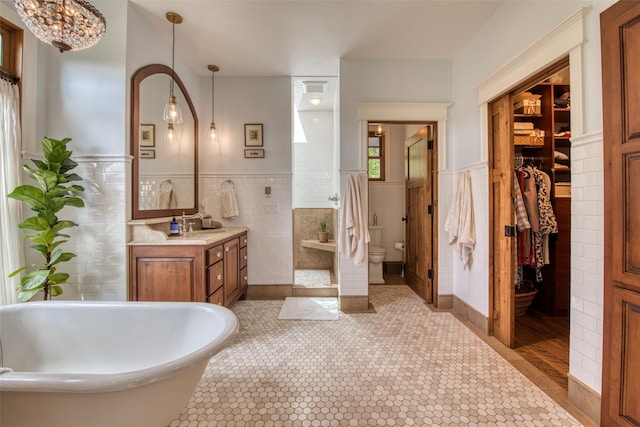 full bathroom with tile walls, vanity, tile patterned flooring, and toilet