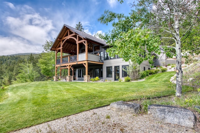 rear view of house with a wooden deck and a yard