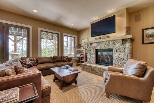 living room featuring light carpet and a stone fireplace