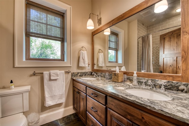 bathroom with vanity, curtained shower, a wealth of natural light, and toilet