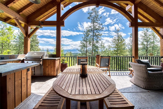 view of patio featuring grilling area, ceiling fan, and exterior kitchen