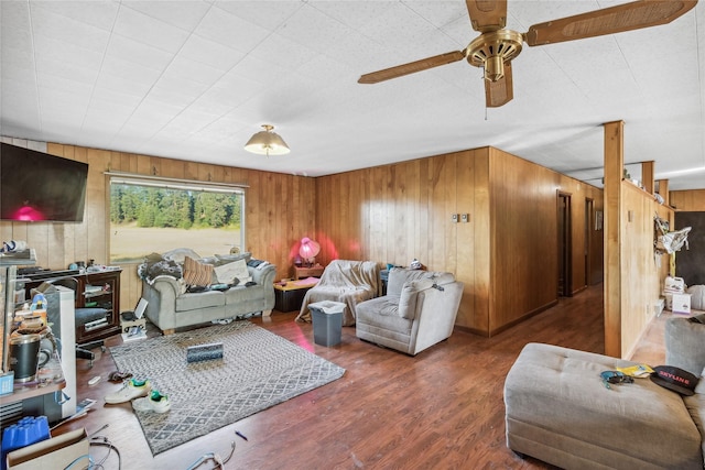 living room featuring wood walls, ceiling fan, and dark hardwood / wood-style floors