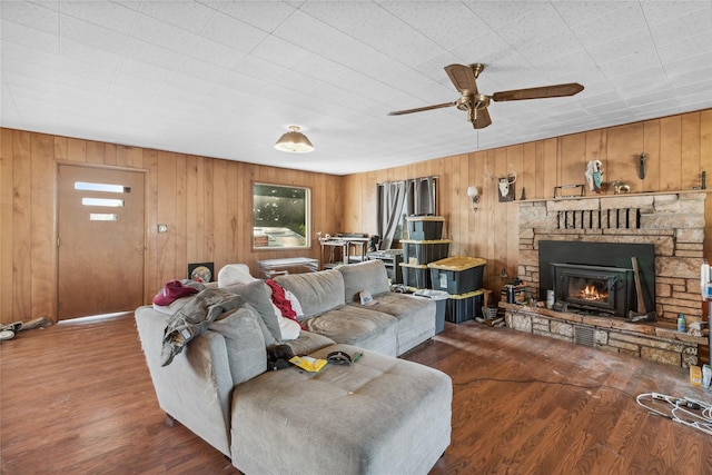 living room featuring plenty of natural light, dark hardwood / wood-style floors, and a stone fireplace