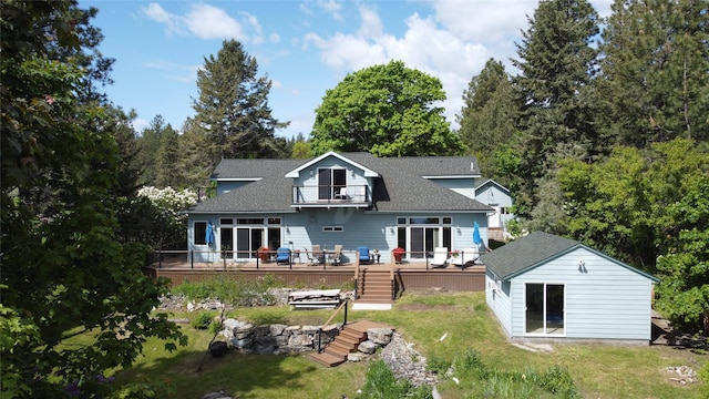 38648 Masumola Rd, Polson, MT 59860 - back of property featuring a balcony, roof with shingles, an outdoor structure, and a yard