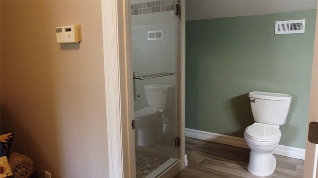 38648 Masumola Rd, Polson, MT 59860 - full bathroom featuring visible vents, a shower stall, baseboards, toilet, and wood finished floors