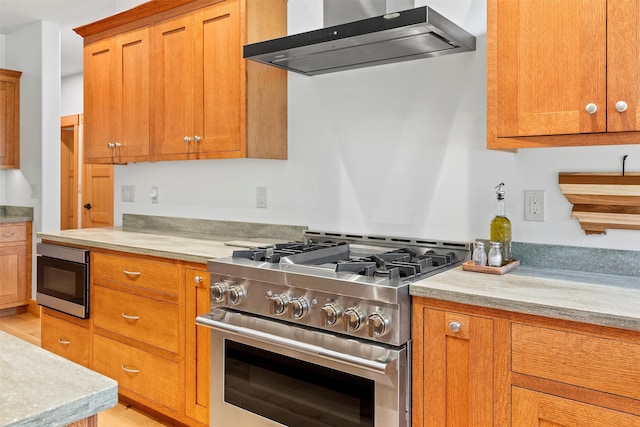 kitchen featuring light hardwood / wood-style flooring, stainless steel stove, and wall chimney exhaust hood