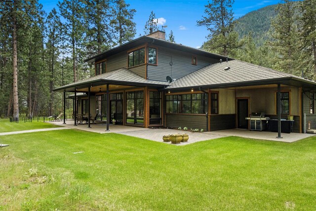 back of house featuring a patio and a lawn