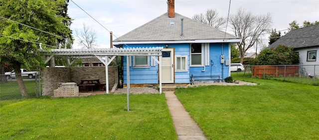 back of house with a pergola and a lawn