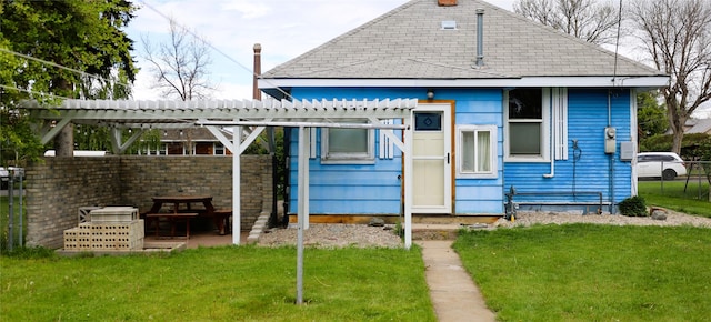 rear view of house featuring a lawn and a pergola