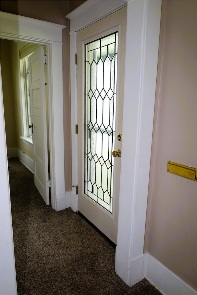 doorway to outside featuring dark colored carpet