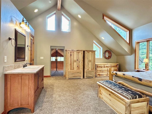 bedroom with light carpet, sink, beam ceiling, and high vaulted ceiling