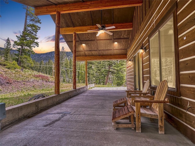 patio terrace at dusk featuring ceiling fan