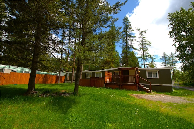 rear view of house with a deck and a lawn