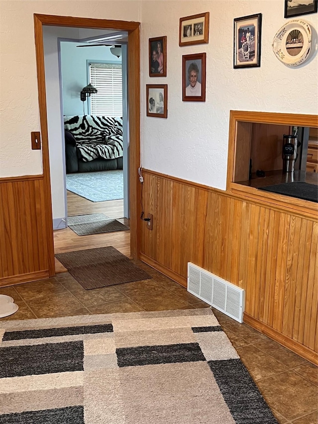 hallway featuring wooden walls