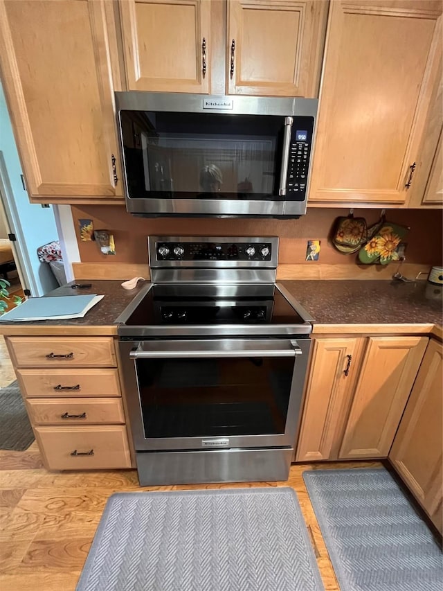 kitchen featuring appliances with stainless steel finishes and light hardwood / wood-style floors