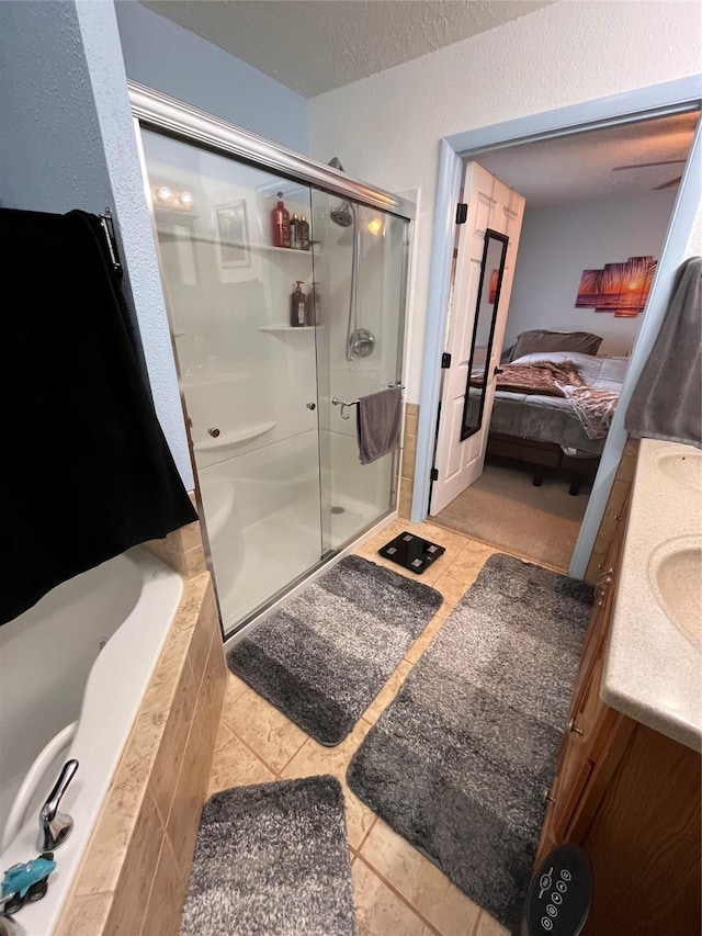 bathroom with tile patterned flooring, vanity, a textured ceiling, and independent shower and bath