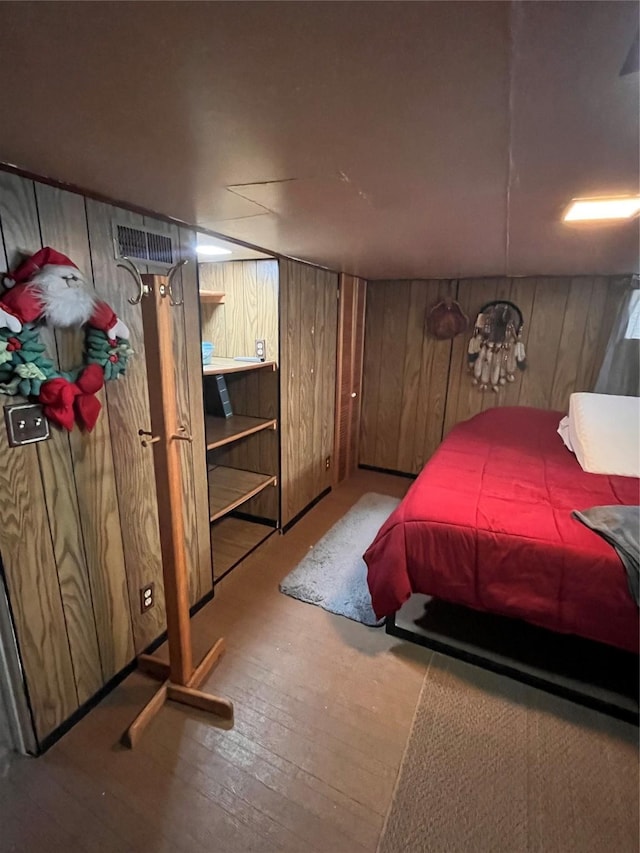 bedroom featuring light wood-type flooring and wooden walls