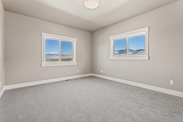 carpeted spare room featuring plenty of natural light