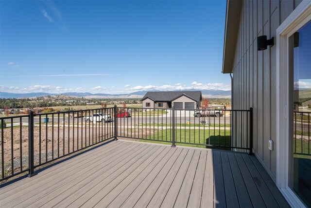 deck with a mountain view and a lawn