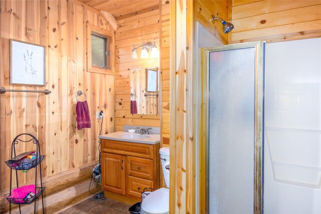 bathroom featuring vanity, toilet, a shower with shower door, and wooden walls